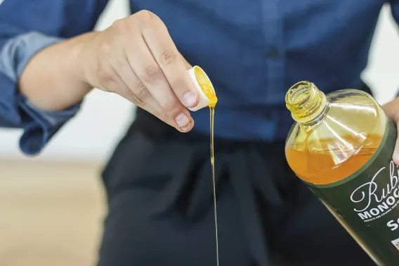Someone is pouring a cup of soap into a bucket