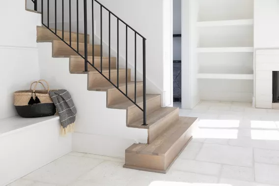 Light wooden staircase in a white room