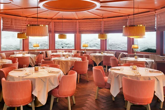A red and pink interior of a restaurant with a red wooden floor in herringbone pattern