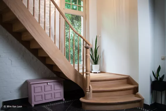 Light staircase in a hallway with pink furniture