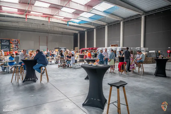 A group of employees is gathered for a family day inside the empty warehouse