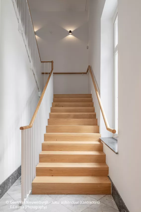 Wooden stairs in a white staircase hall