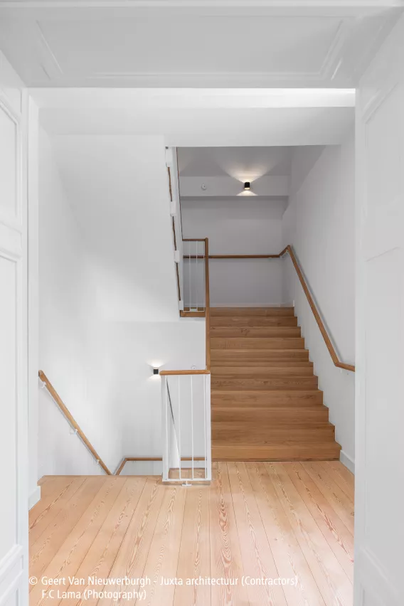 Wooden stairs in a white staircase hall