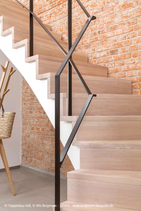 Light wooden staircase with brick background
